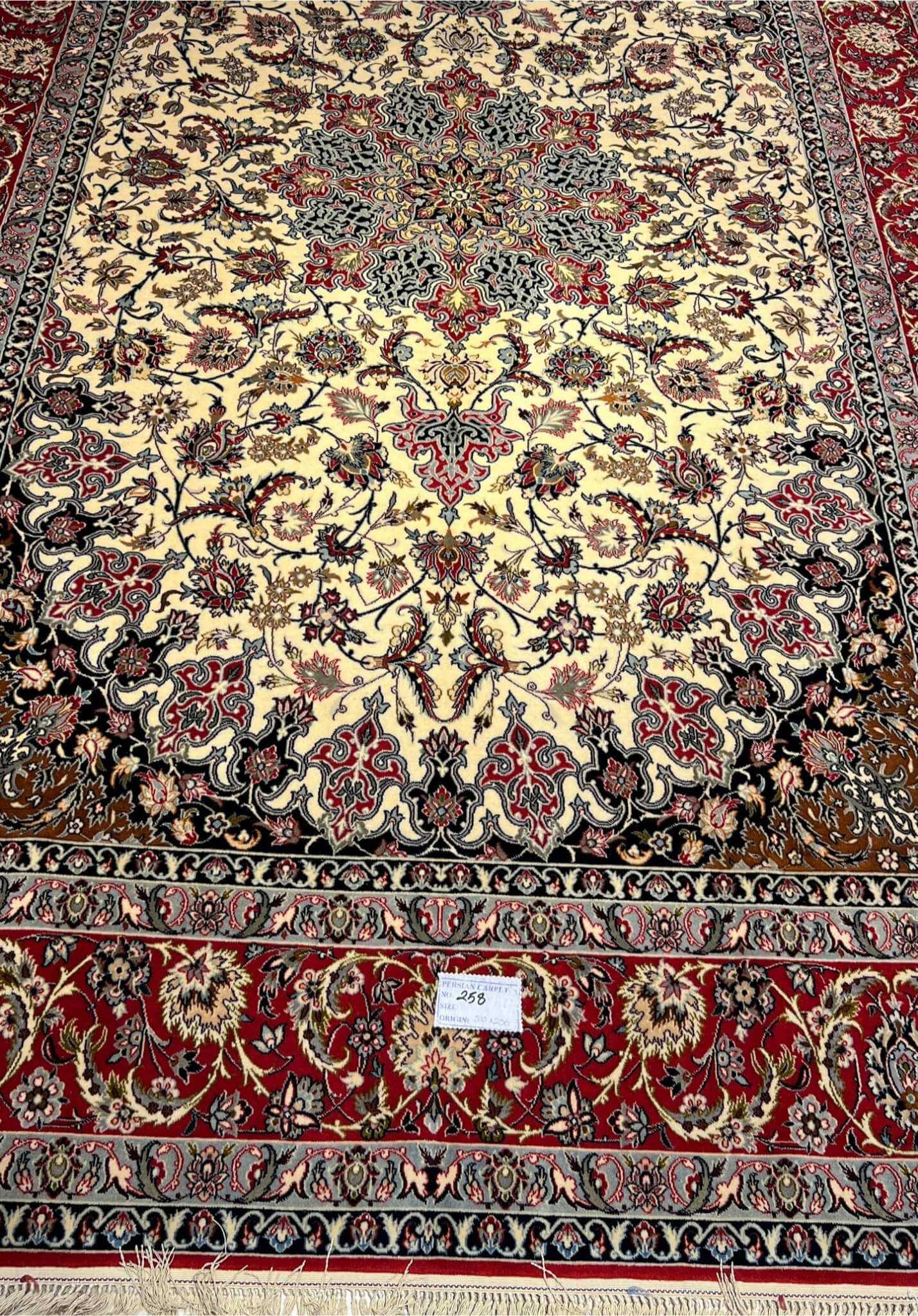 Hand-knotted wool and silk rug in ivory, red, and black.